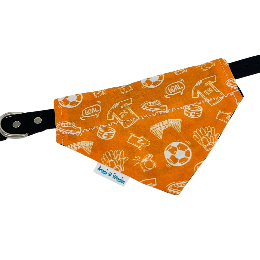 Flat-lay of the Houston Dynamo-inspired dog bandana attached to a collar, highlighting the front side's soccer themed design. A stylish and comfortable pet bandana for Houston soccer fans and their pups.