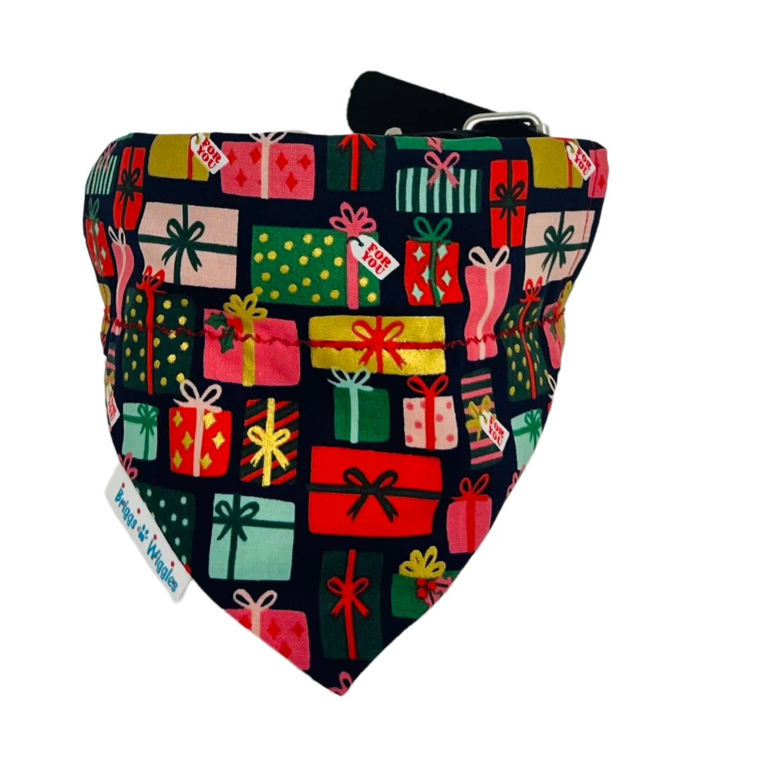 Bright metallic Rifle Paper Co. holiday dog bandana with colorful gold-accented gifts on the front side.
