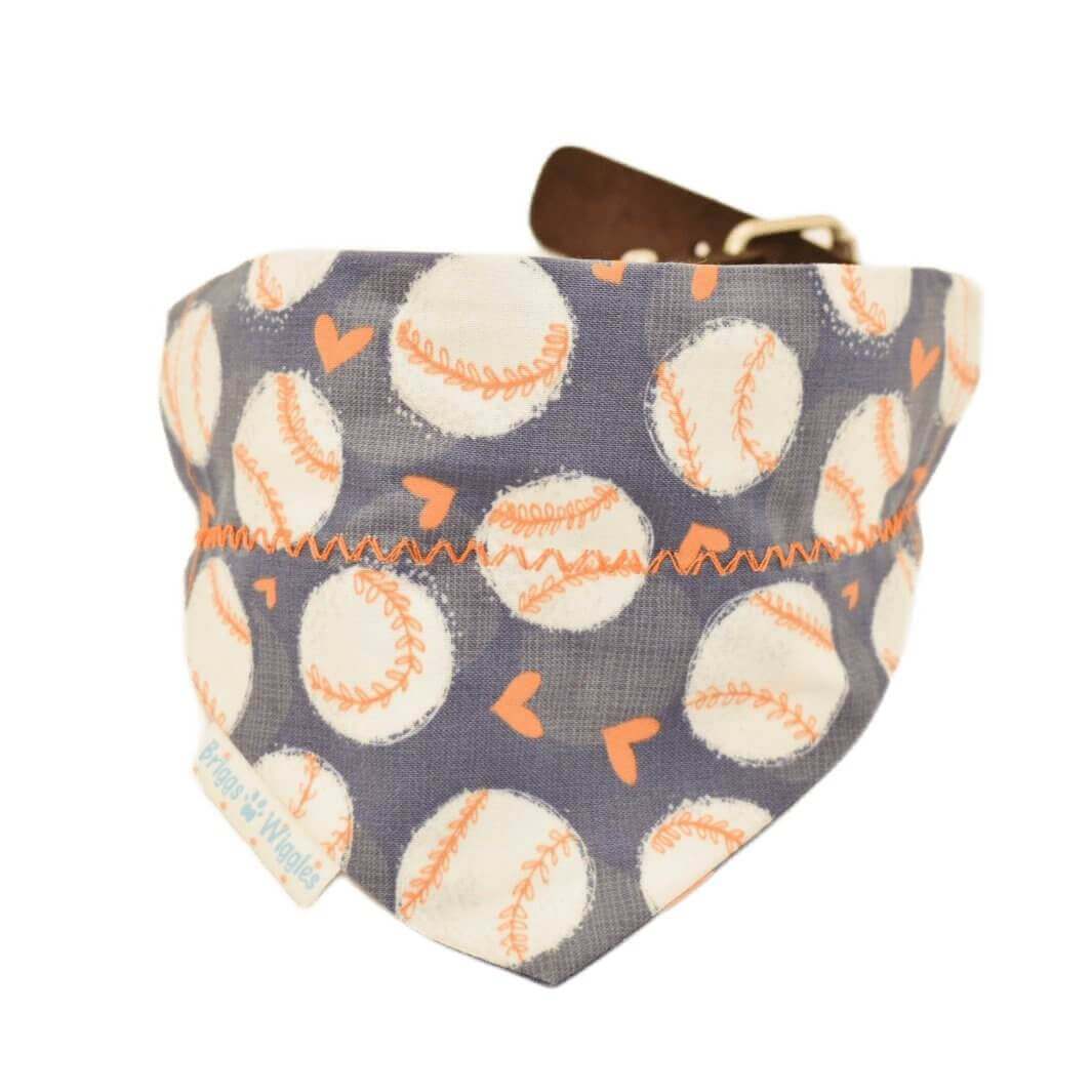 Close-up of a handmade Astros inspired dog bandana showcasing floating baseballs and orange hearts on a navy background with reversible styling.