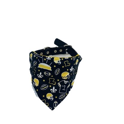 close-up of a Saints-themed dog bandana highlighting detailed elements like the Superdome, fleur-de-lis, footballs, and the state of Louisiana in black and gold.